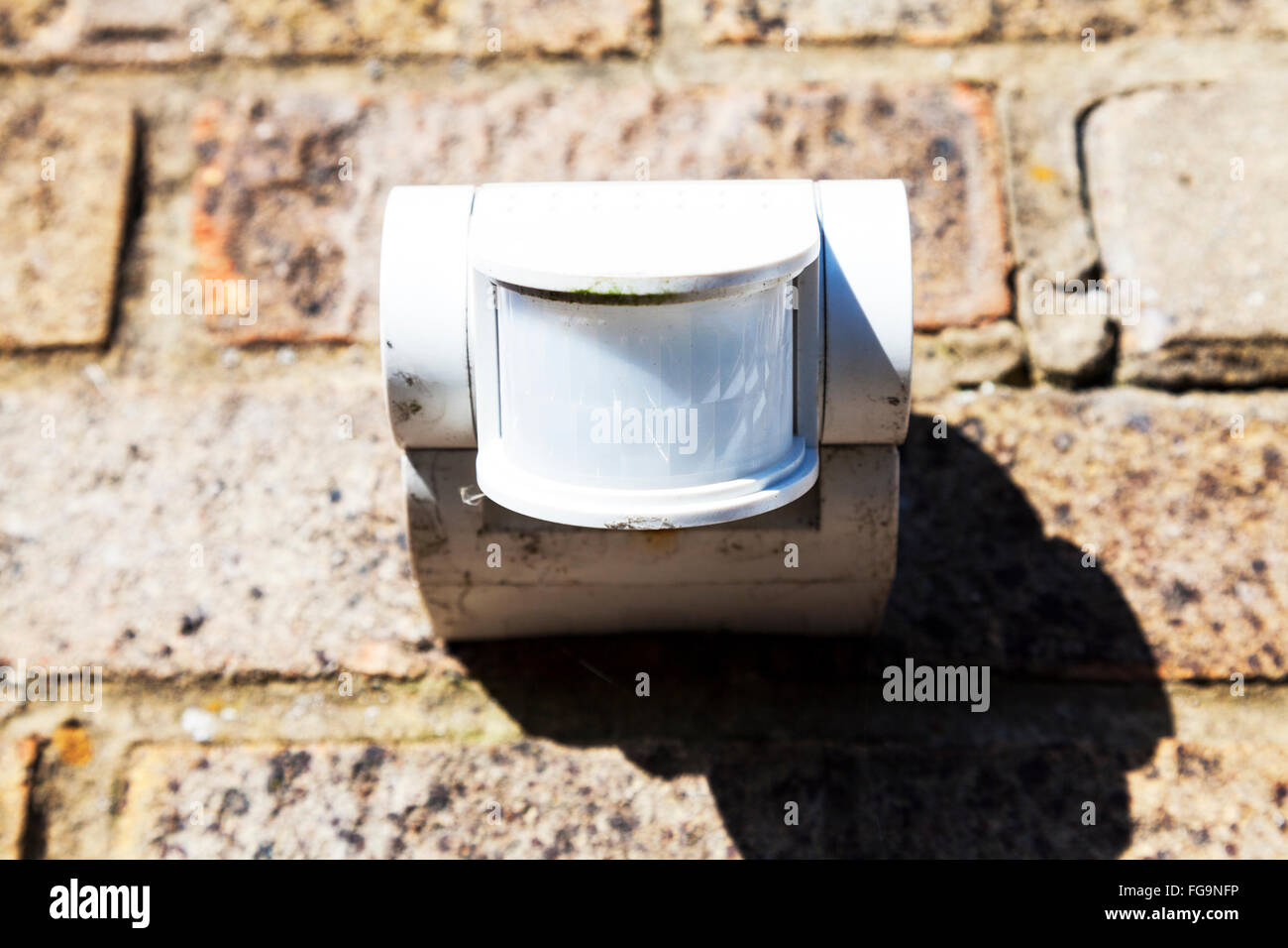 Movement sensor mounted on wall security detect moving detects people UK England GB Stock Photo