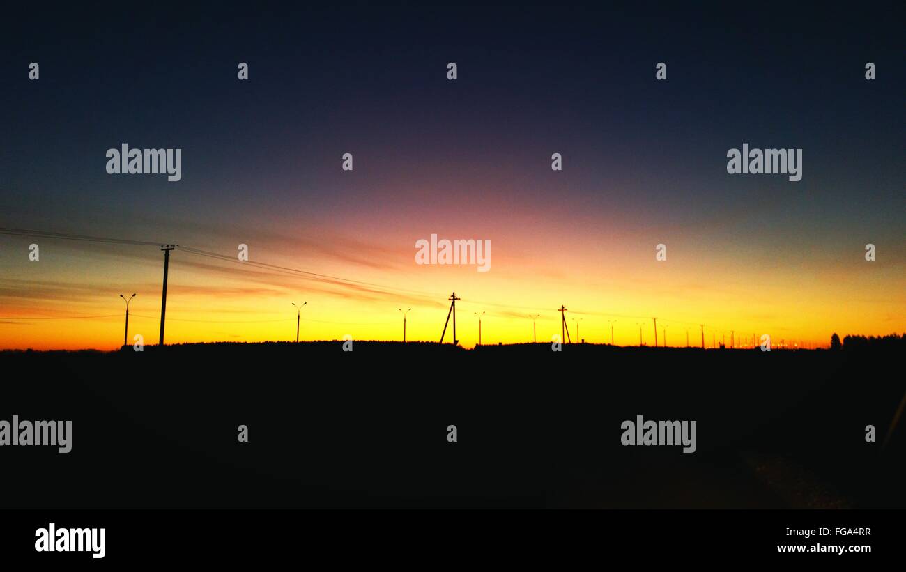 Electricity Pylons On Silhouette Landscape During Sunset Stock Photo ...