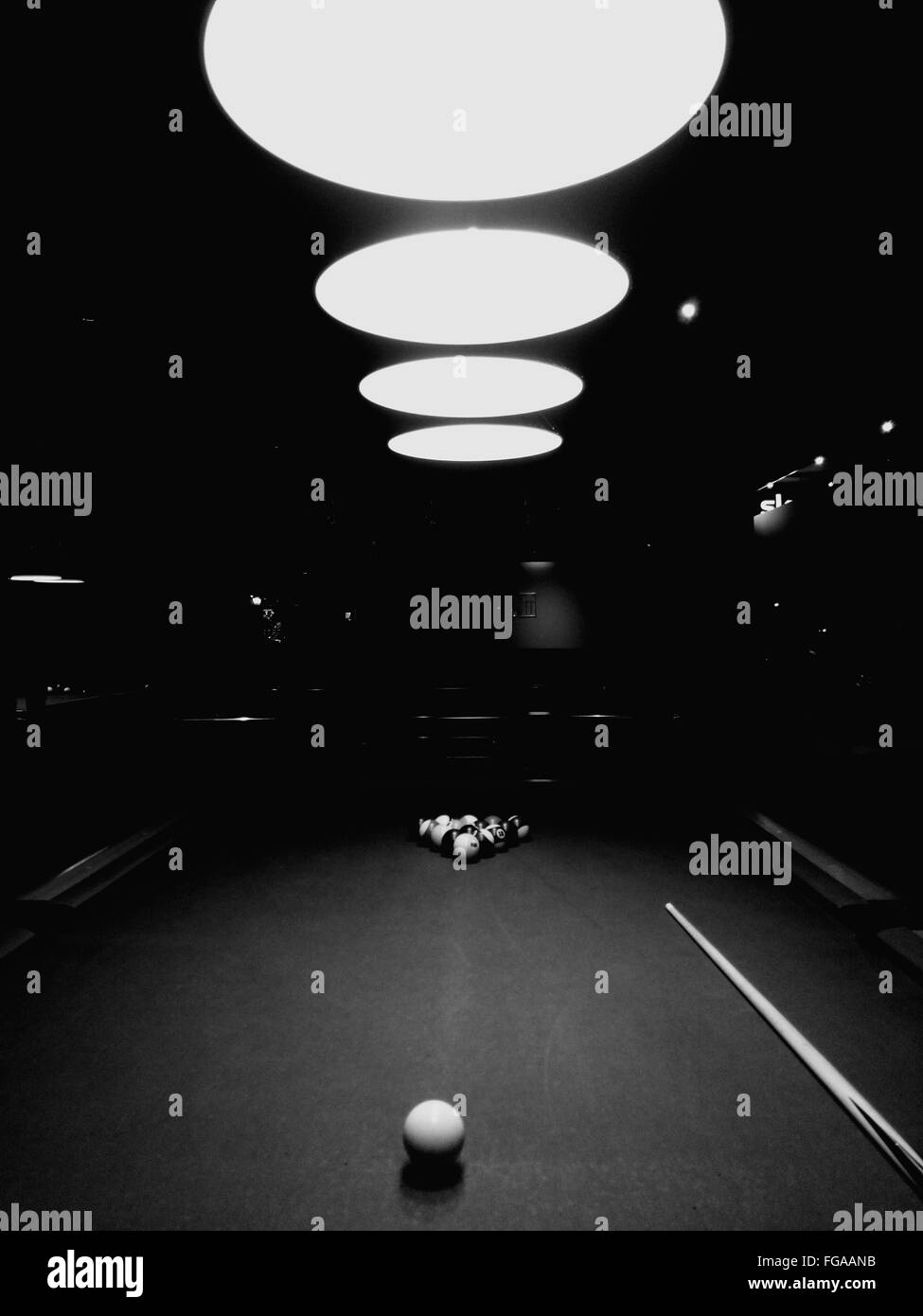 Pool Table Against Illuminated Pendant Lights Stock Photo