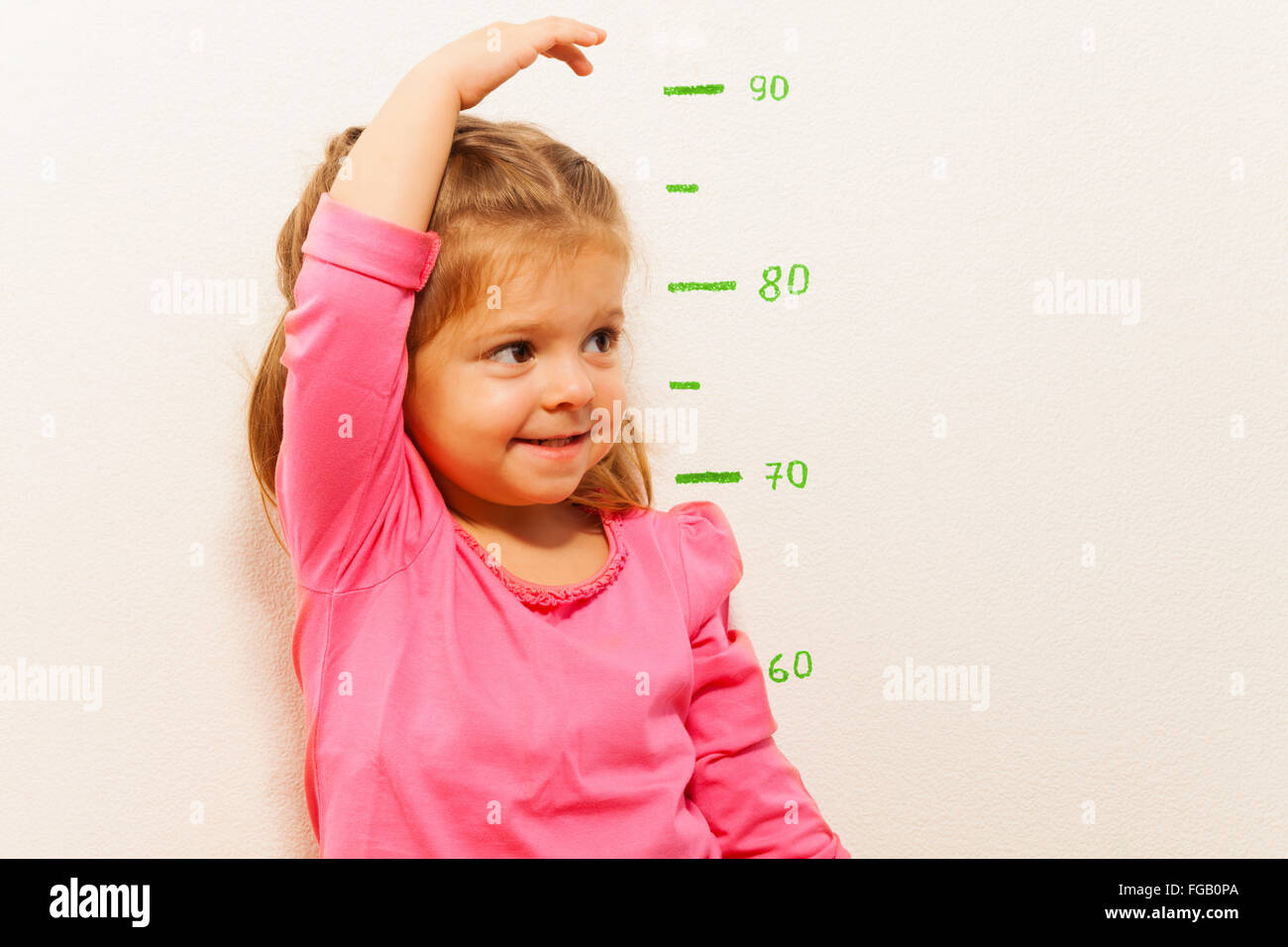 Height measurement by little girl at the wall Stock Photo