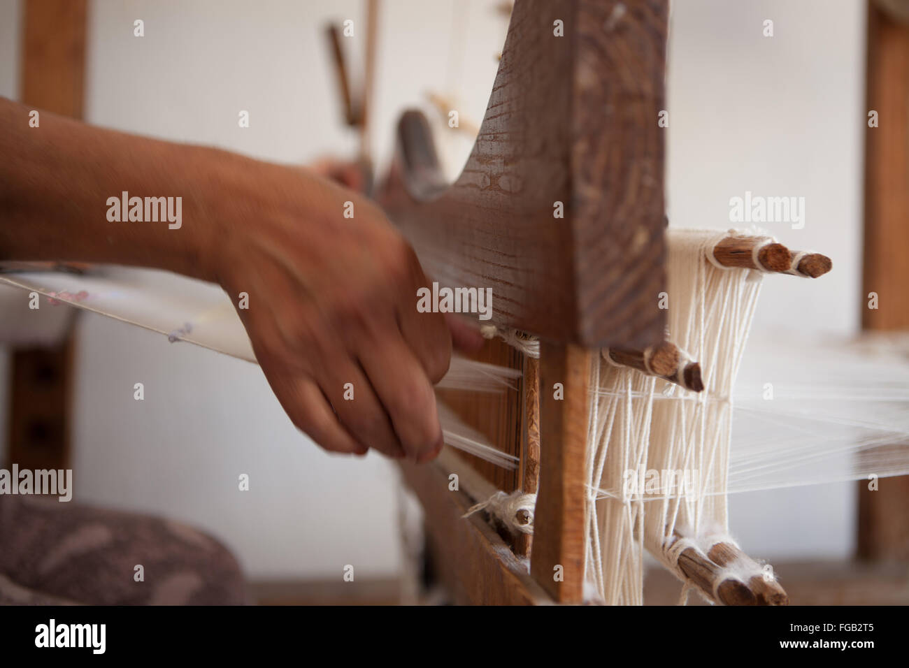 A close up of a women's hands working a cotton loom. Stock Photo
