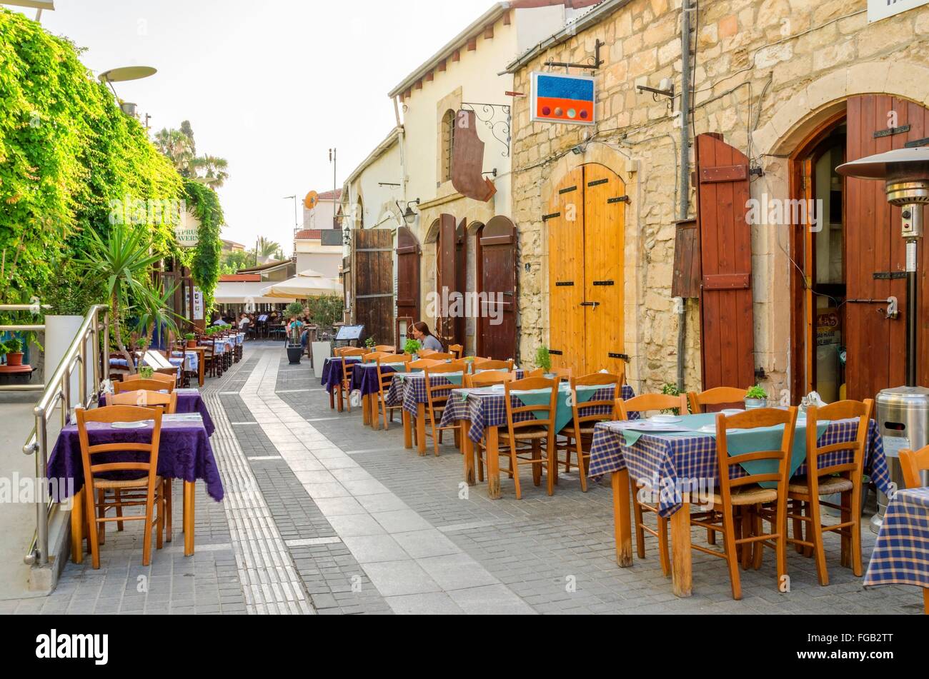 An alley in the historic medieval city center of Limassol in Cyprus. A view of the cafe, restaurant, cypriot taverna, tables and Stock Photo