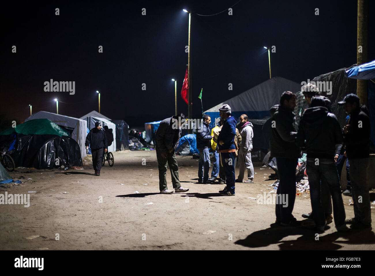 Refugees and migrants in the main street of the Jungle refugee camp in Calais, France Stock Photo