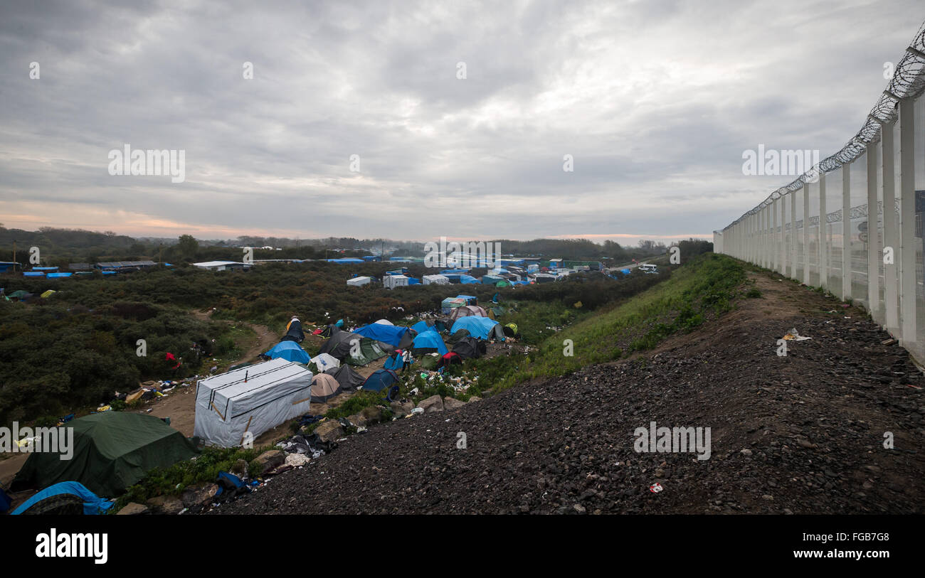 An overview of the jungle refugee camp in Calais, overlooked by a huge razor wire fence to prevent access to the ferry terminal. Stock Photo