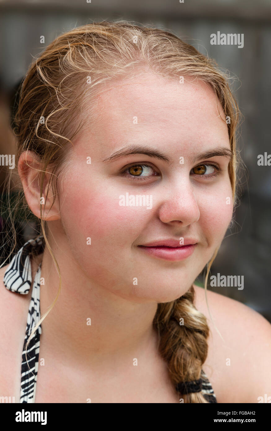 Teenage Caucasian teenager with wet hair after swimming. She is happy