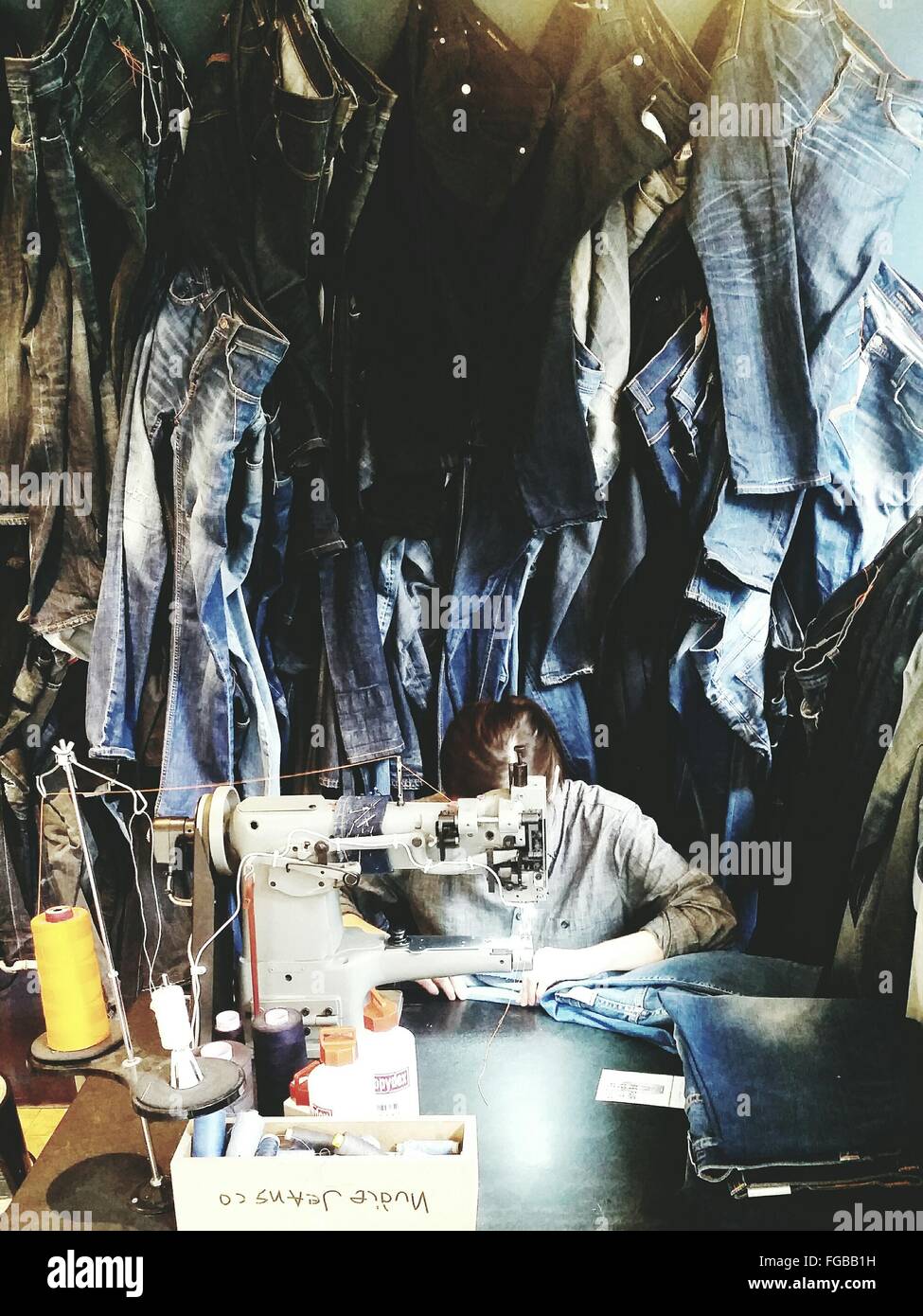 Woman Sewing Jeans In Factory Stock Photo Alamy
