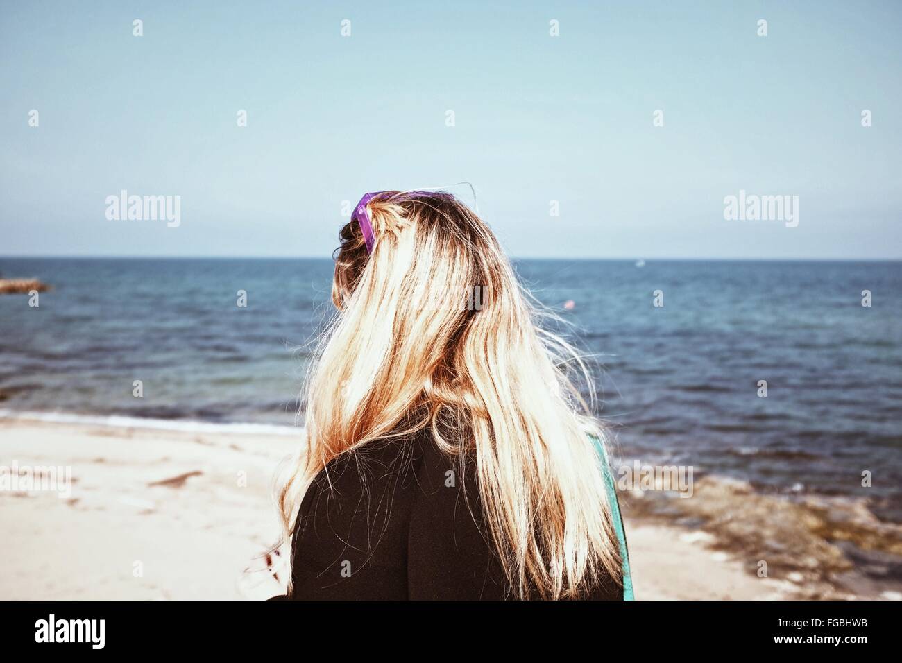 Rear View Of Woman On Beach Against Clear Sky Stock Photo