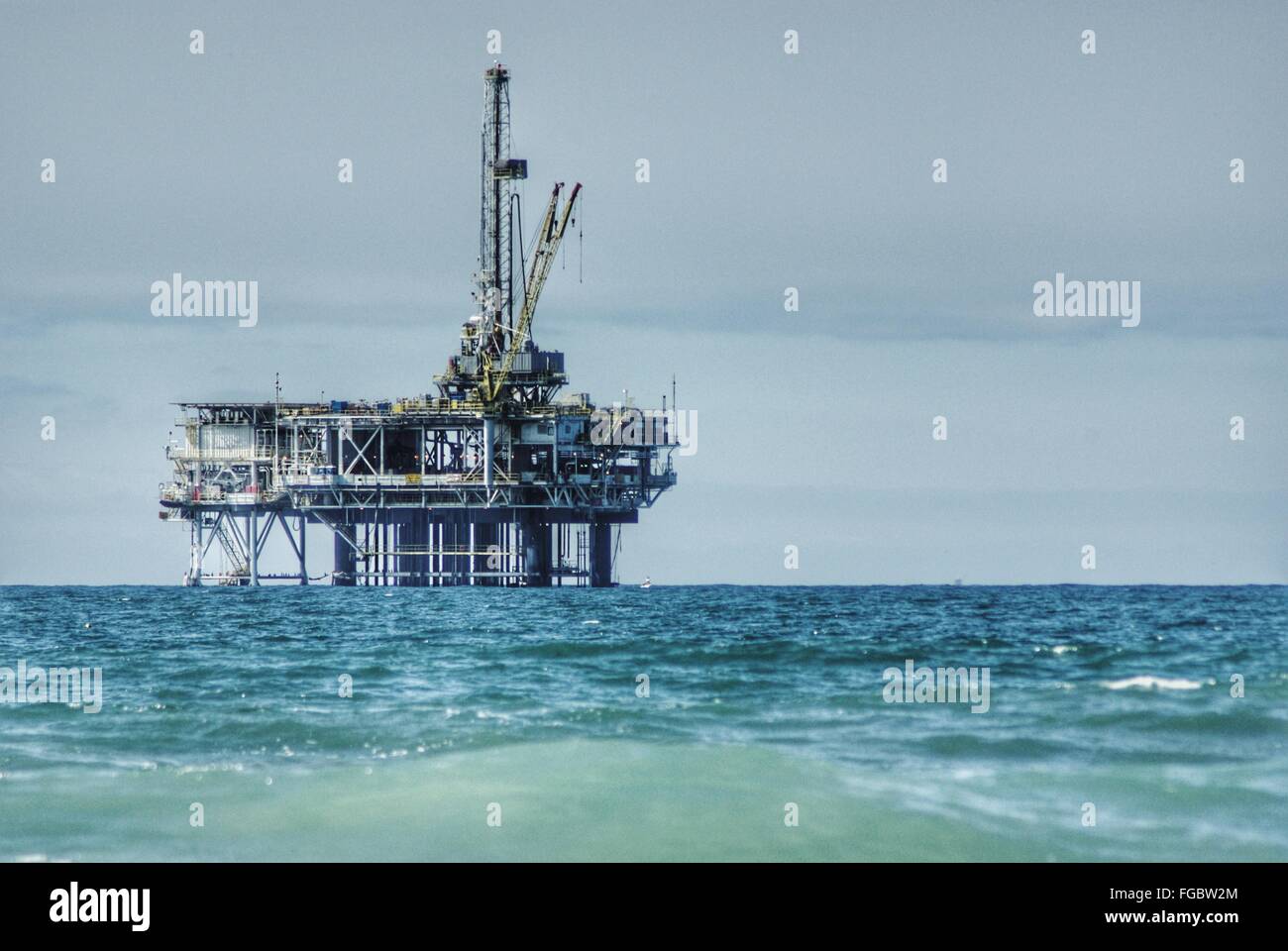 Oil Rig In Sea Against Sky Stock Photo