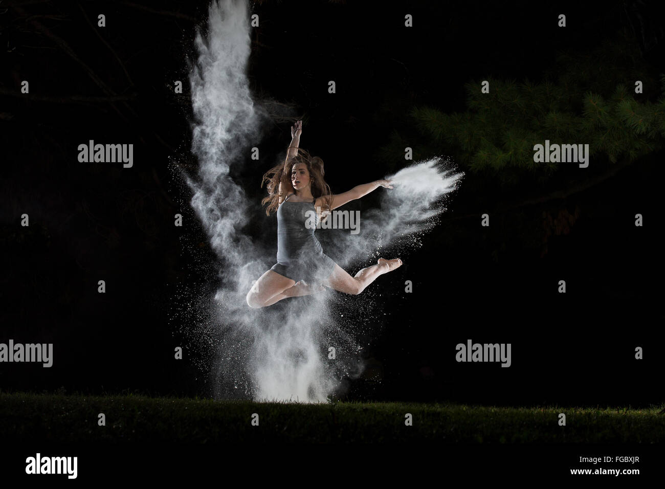 ballet dancer make a leap through a burst of flour Stock Photo
