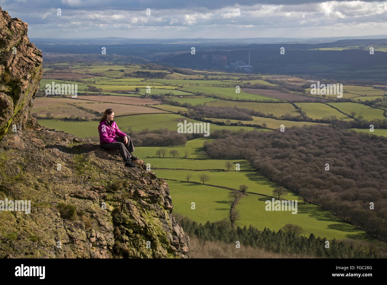 Female looking out from the top of the Wrekin hill in Shropshire, England. Ironbridge Power Station in the far distance. Stock Photo