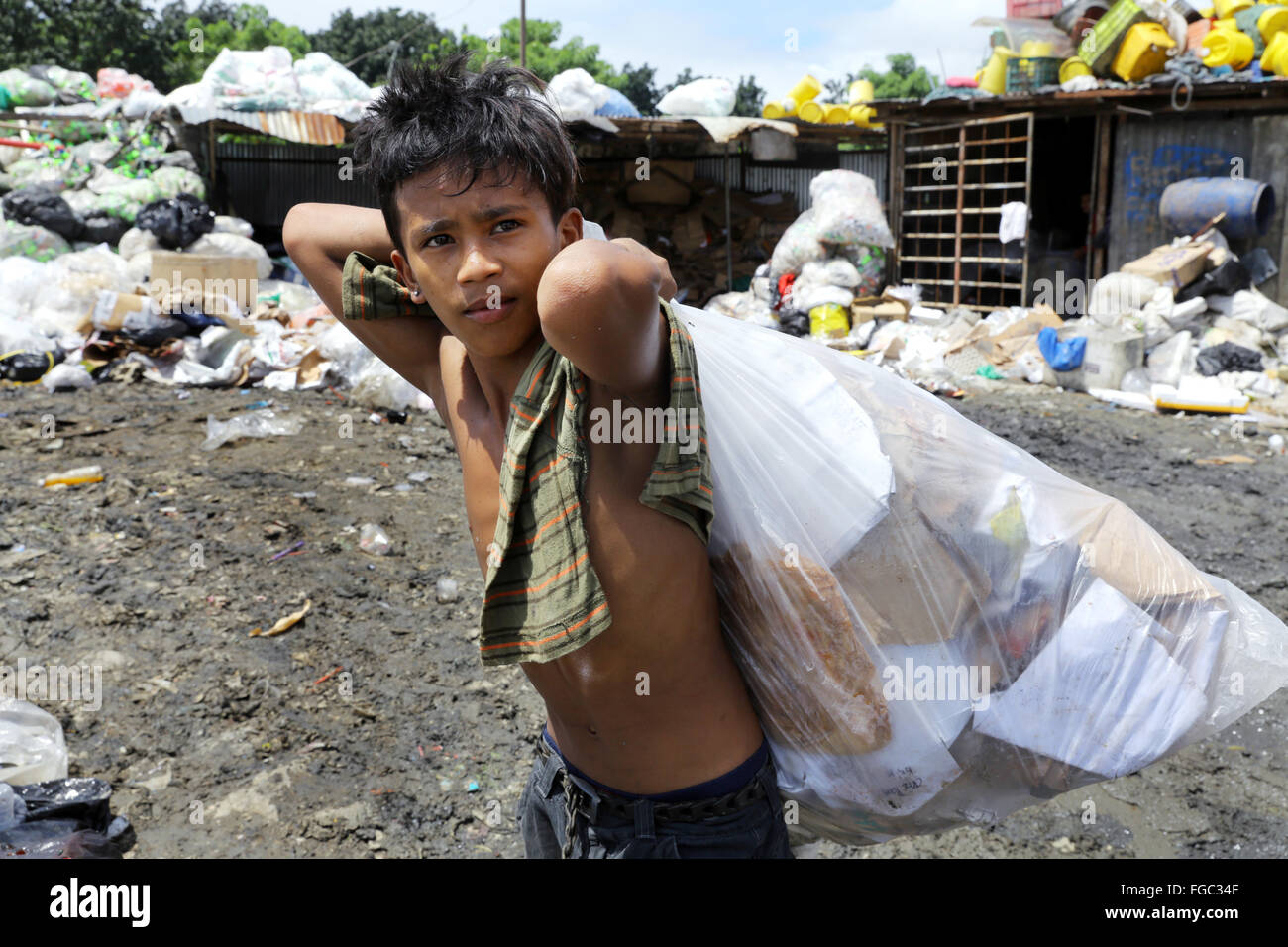 Boy (14) works in a waste separation and resale in a Junk Shop near the Quezon City Integrated Waste Disposal Facility at Barangay (village) Payatas in Quezon City, Metro Manila, The Philippines Stock Photo
