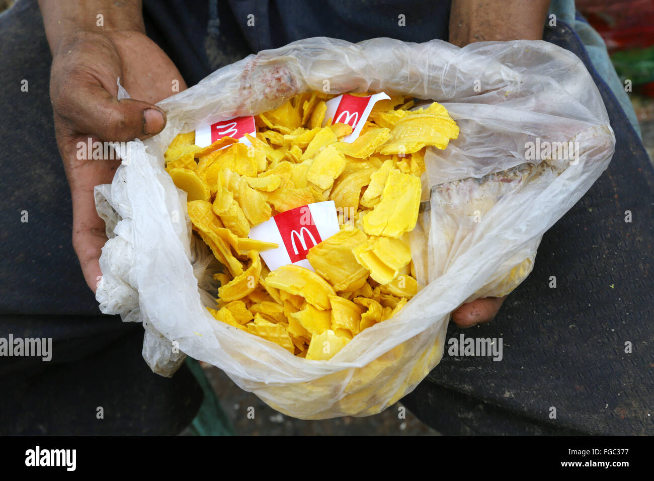 Young man eats leftover food from McDonalds found in waste at the landfill Quezon City 'Integrated Waste Disposal Facility' at Barangay (village) Payatas in Quezon City, Metro Manila, The Philippines Stock Photo