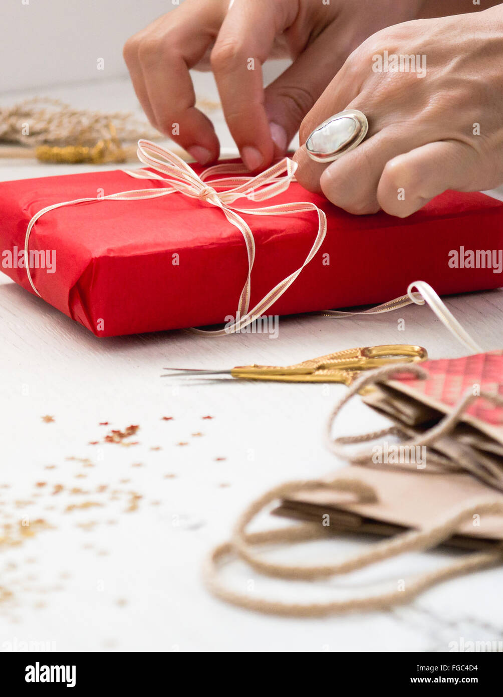 Cropped Image Of Hand Tying Ribbon On Gift At Table Stock Photo Alamy