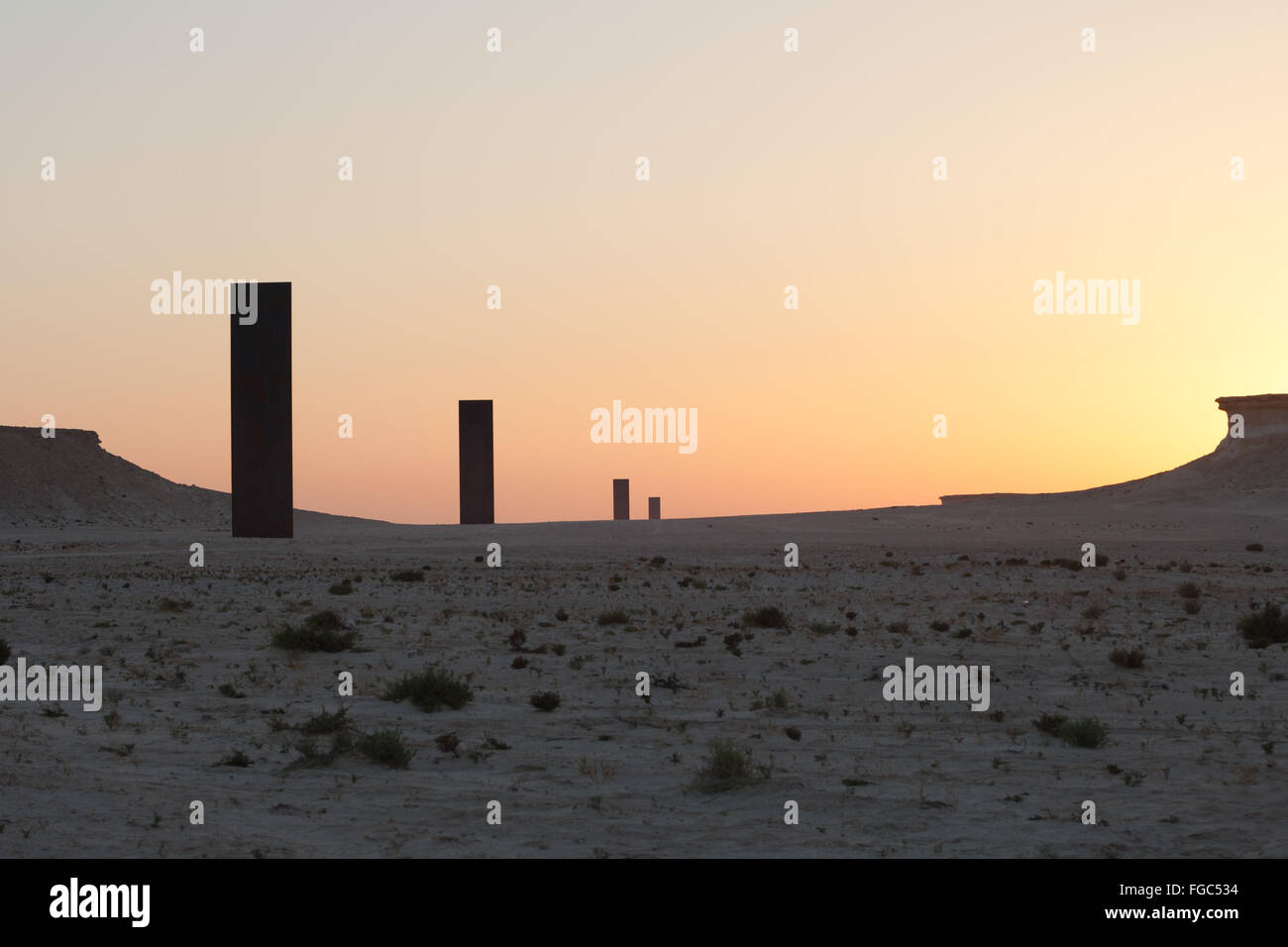 Sunset over East West West East in the Qatari desert. Public art installation by  East West-West East.  Richard Serra commissioned by Qatar Museums Authority. Stock Photo