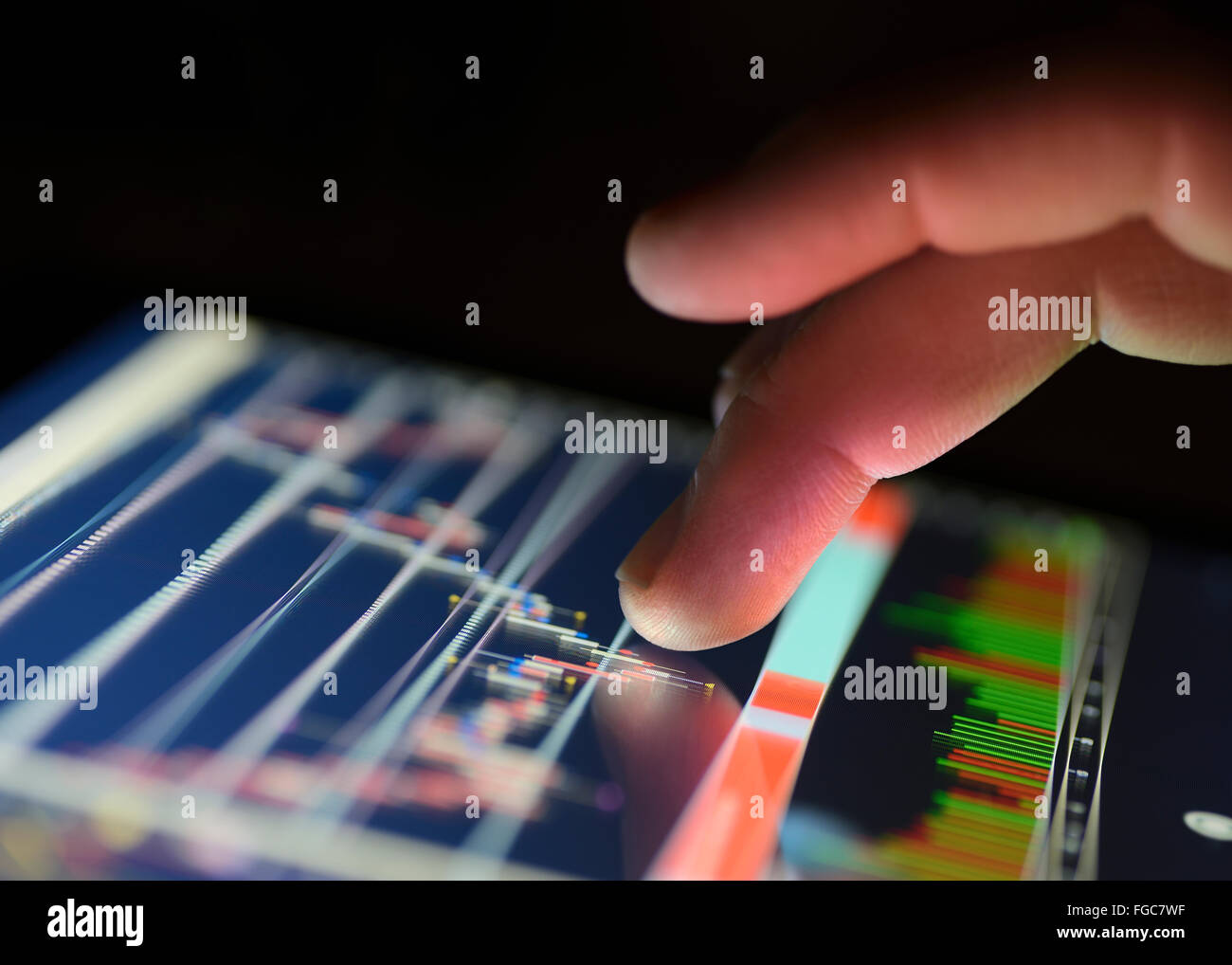 Traders finger using the touchscreen of a digital tablet displaying a financial Market graph. close up. Stock Photo
