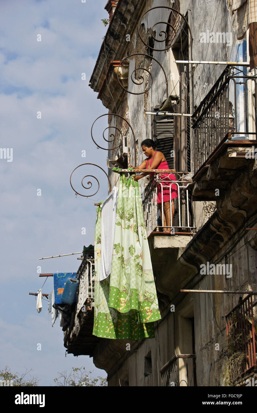 Woman hanging laundry from her balcony, Habana Vieja (Old Havana), Cuba Stock Photo