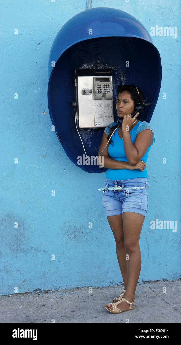 Girl using public pay telephone, Cienfuegos, Cuba Stock Photo