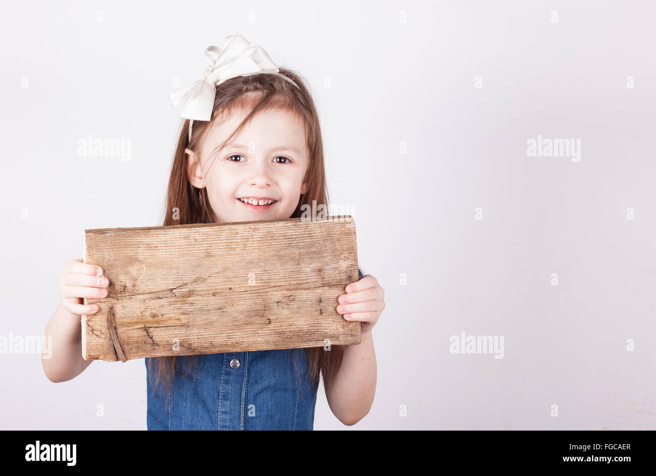 young girl, empty wooden board in hands, white background Stock Photo