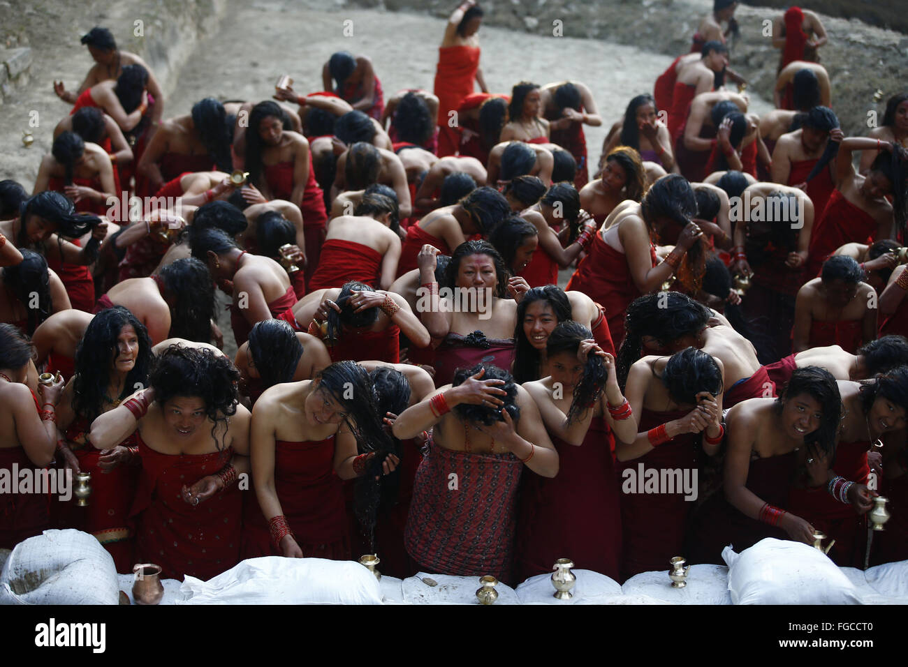 Bhaktapur, Nepal. 19th Feb, 2016. Nepalese Hindu devotees bathe after offering prayers on a temporary pond during the month-long Swasthani Bratakatha festival, devoted to goddess Shree Swasthani in the premise of an ancient Hindu temple of Changu Narayan in Bhaktapur, Nepal on Friday, February 19, 16. Men devotees recite Holy Scripture and women pray for wellbeing of their spouses throughout the month-long fast via travelling barefooted to holy shrines for worship. Credit:  Skanda Gautam/ZUMA Wire/Alamy Live News Stock Photo