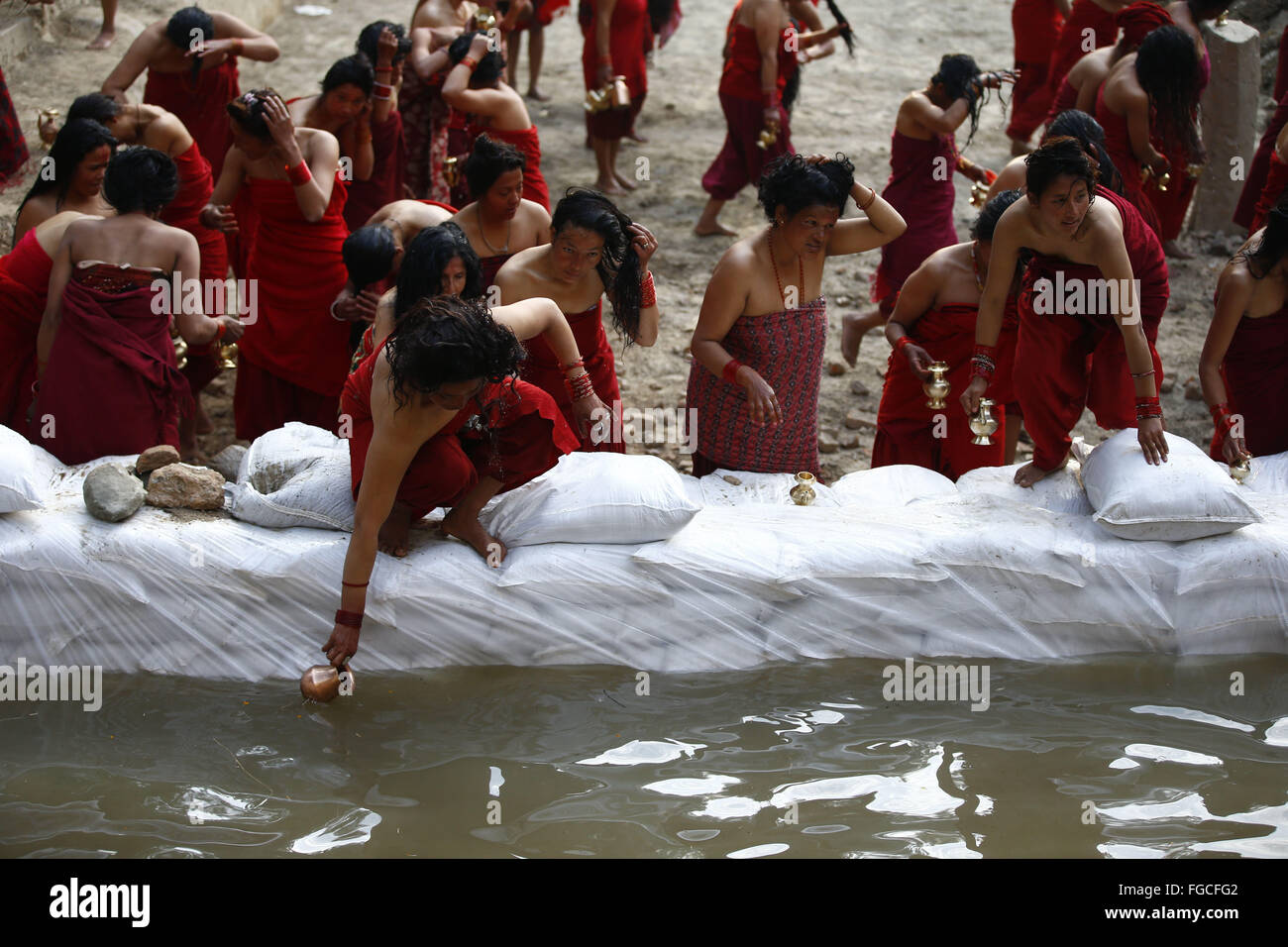 Bhaktapur, Nepal. 19th Feb, 2016. Nepalese Hindu devotee women head to a temporary pond to collect holy water after bathing and offering prayers during the month-long Swasthani Bratakatha festival, devoted to goddess Shree Swasthani in the premise of an ancient Hindu temple of Changu Narayan in Bhaktapur, Nepal on Friday, February 19, 16. Men devotees recite Holy Scripture and women pray for wellbeing of their spouses throughout the month-long fast via travelling barefooted to holy shrines for worship. Credit:  Skanda Gautam/ZUMA Wire/Alamy Live News Stock Photo