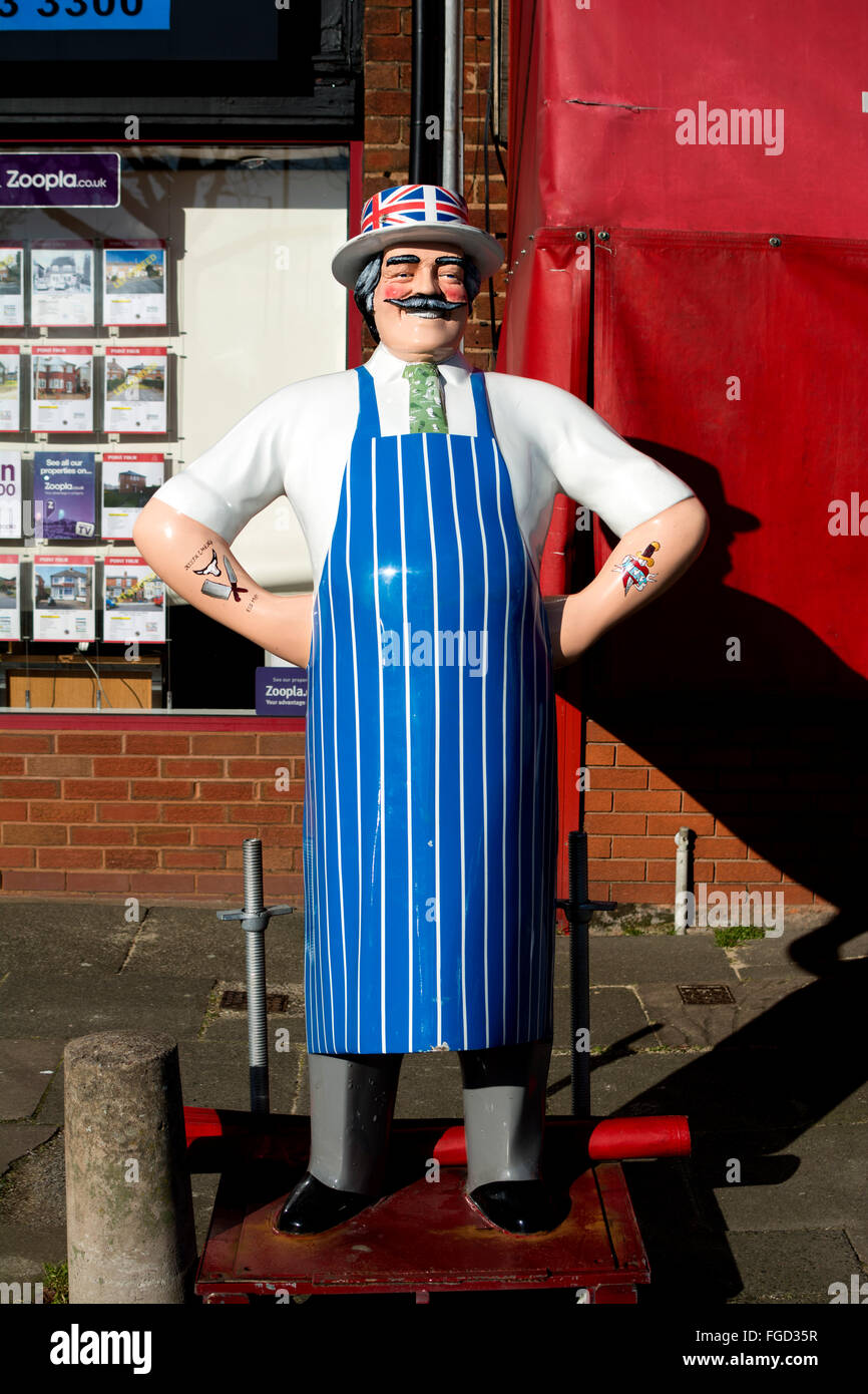 Figure outside butchers shop, Hall Green, Birmingham, UK Stock Photo