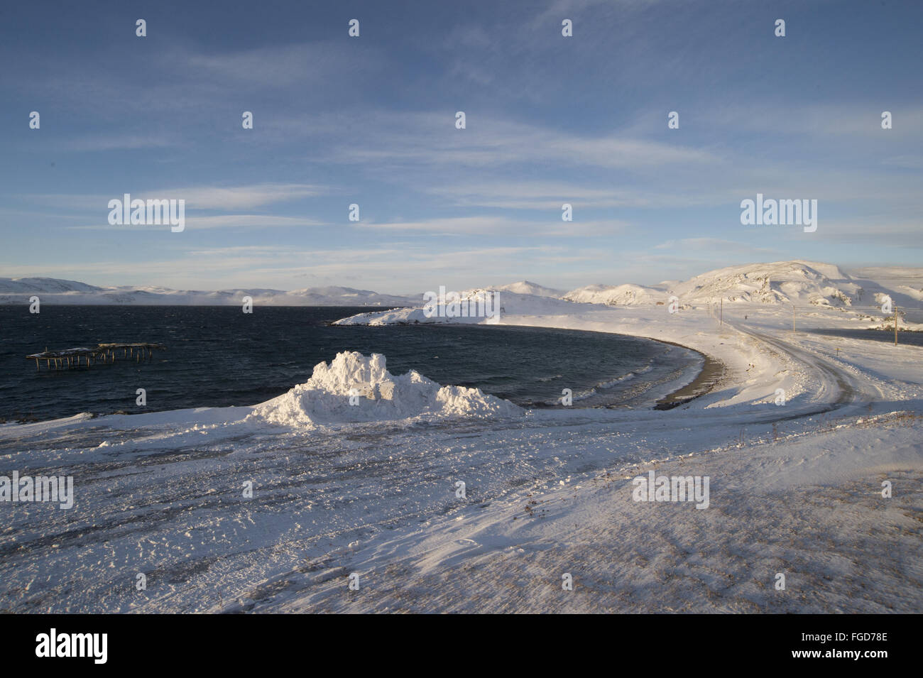 View of snow covered road and fjord coastline, Kongsfjord, Varanger, Finnmark, Norway, March Stock Photo