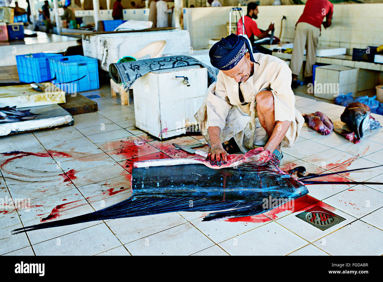 Man cutting a sailfish at fish market in Muscat, the capital of Oman. Stock Photo