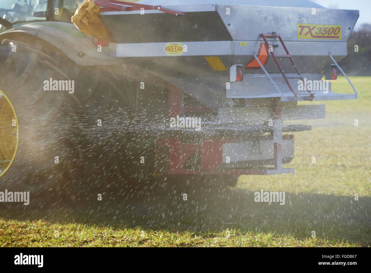 Tractor with Bredal TX 3500 spreader, spreading chemical fertilizer on field, Sweden, April Stock Photo