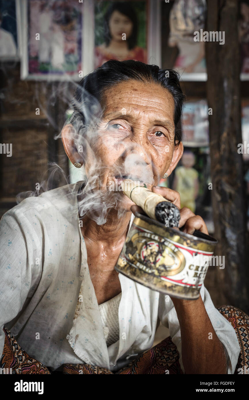 smoking old tobacco Old woman smoking a big cigar made out of tobacco and corn leaves Stock  Photo