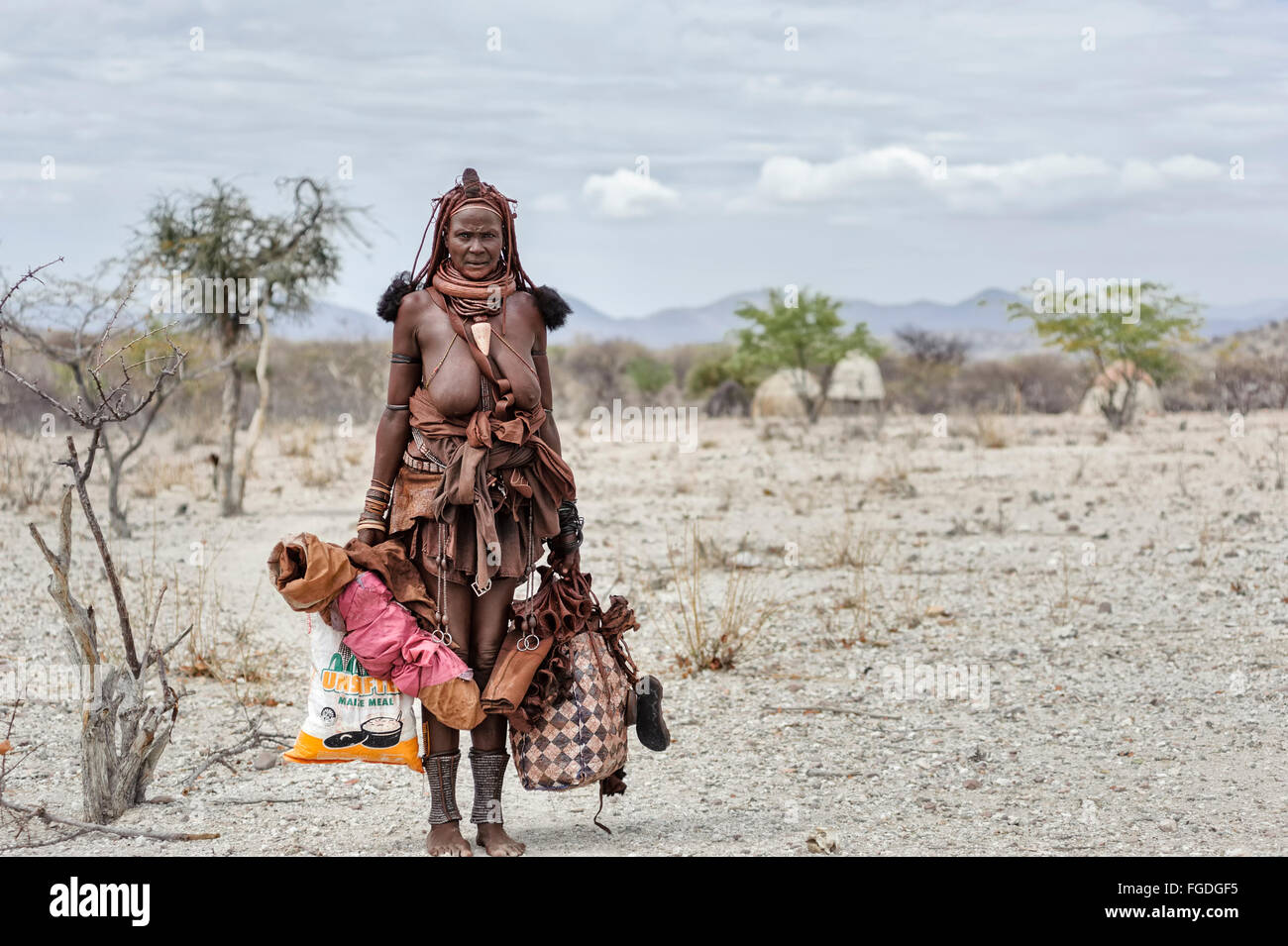 Himba woman loaded with lots of packs ready to travel. 