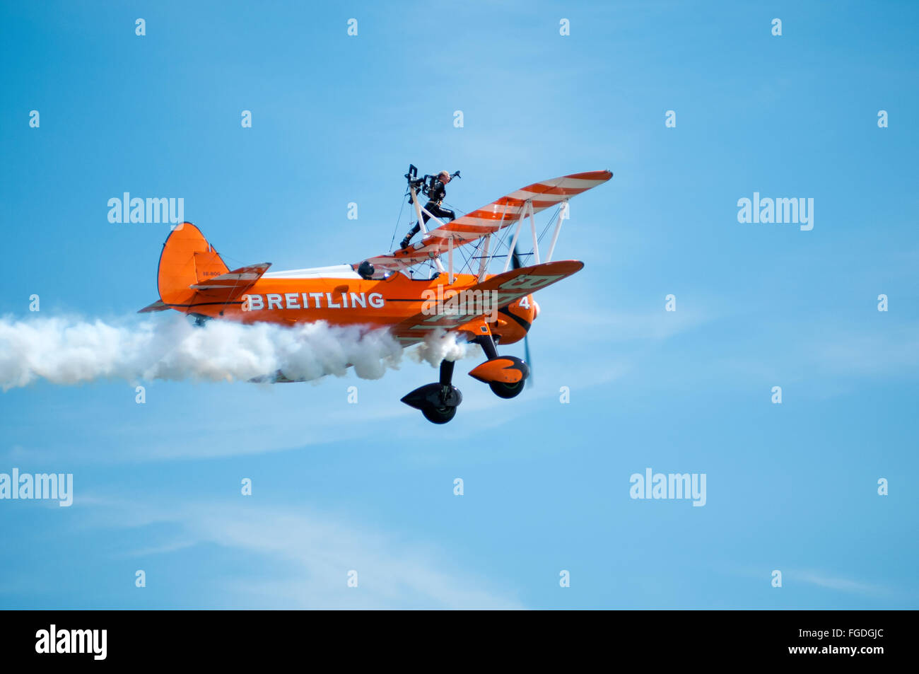 A display of 'wing walking' upon the wing of a Boeing Stearman aircraft during an air show. Stock Photo