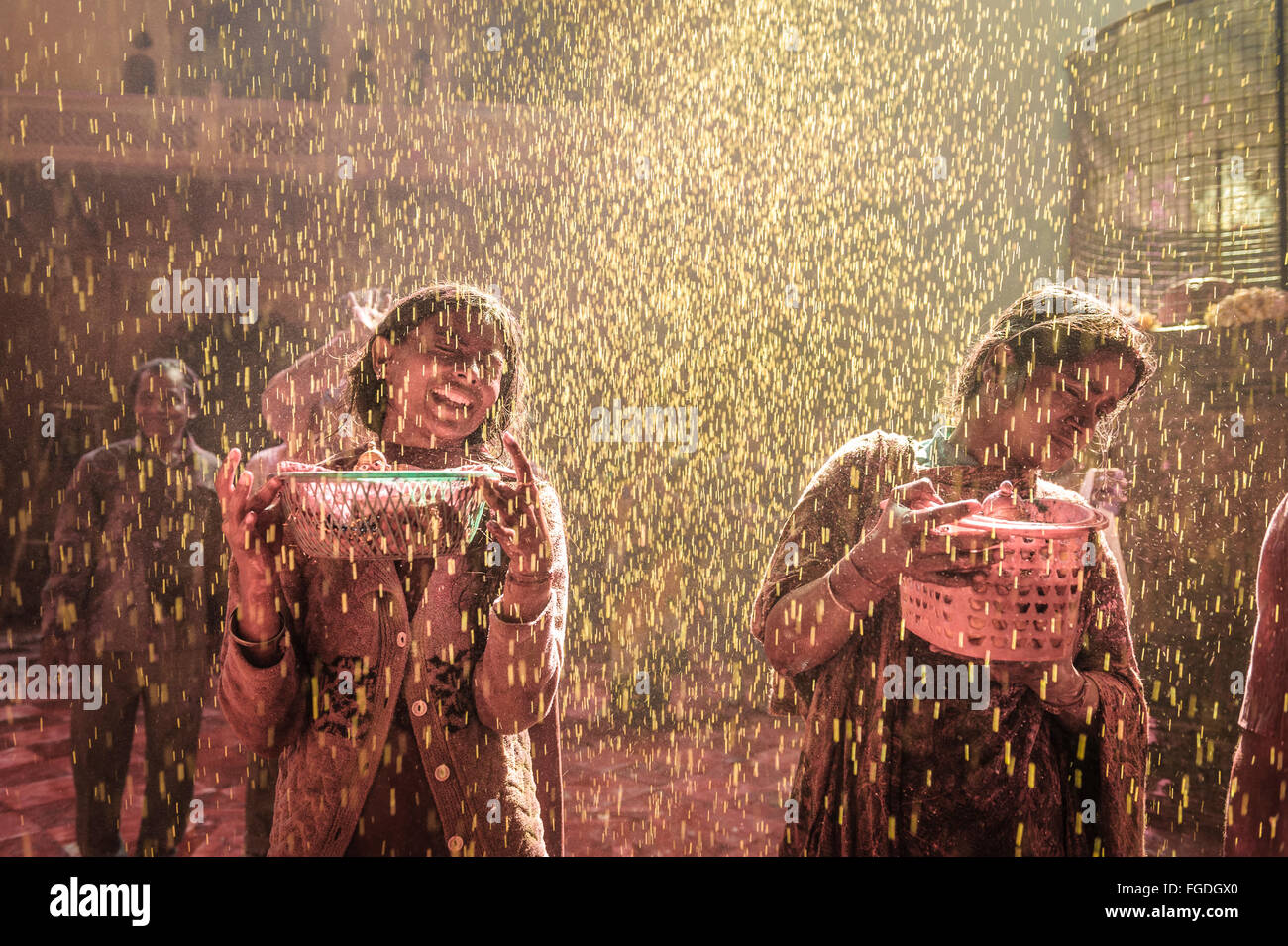 Two girls splashed with yellow water during the celebration of Holi. Stock Photo