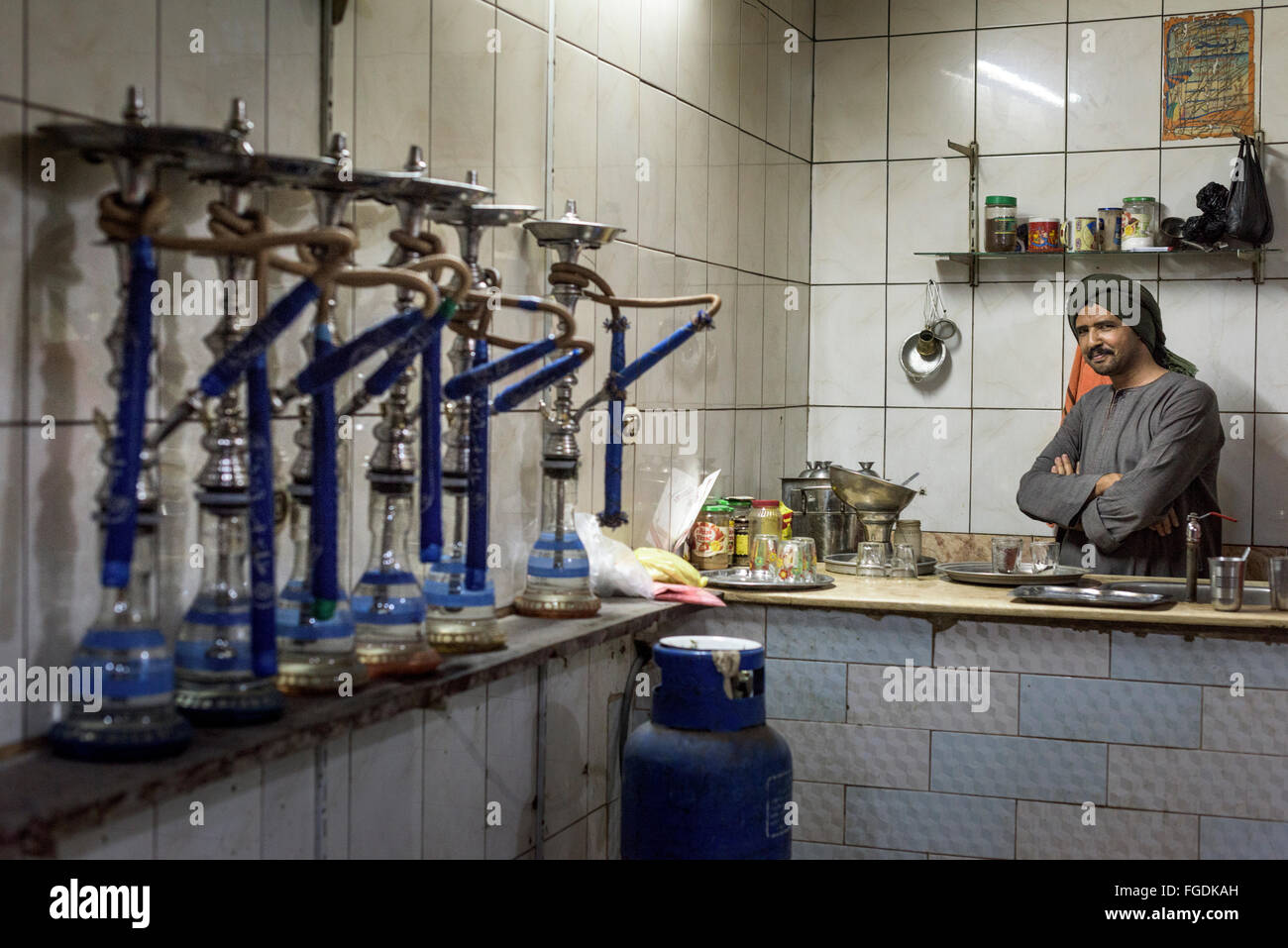Egyptian waiter inside his small shisha bar, where people comes to smoke water pipes and play games. Stock Photo