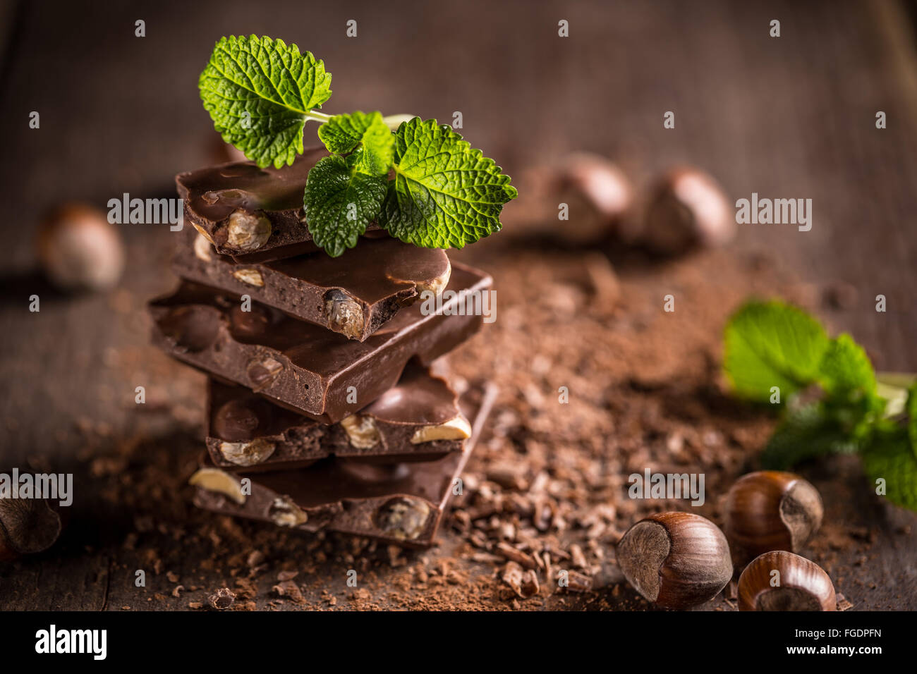 Stack of chocolate slices with mint leaf on a wooden table Stock Photo