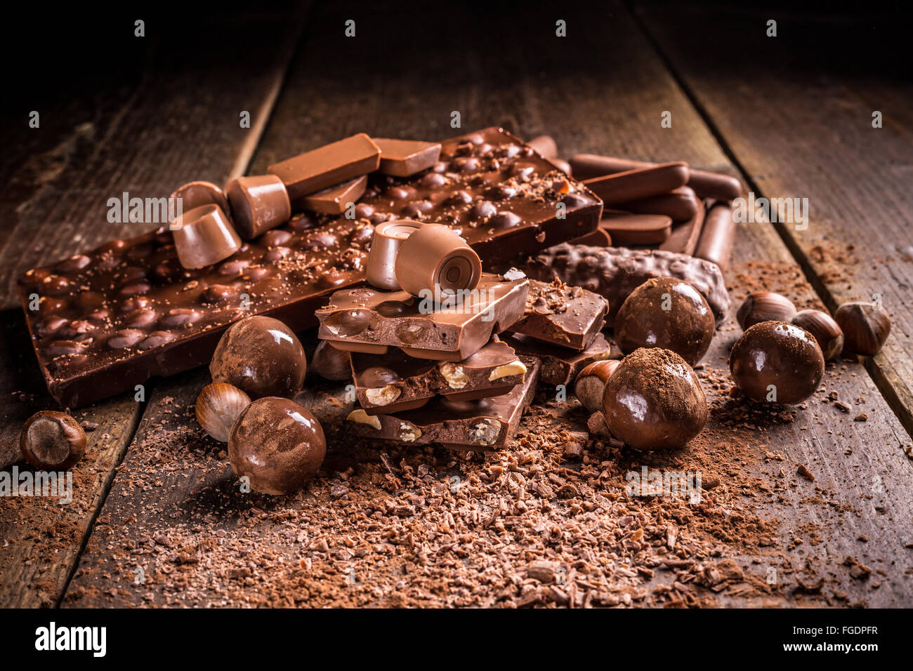 Tasty sweets chocolates and pralines on rustic wooden board Stock Photo