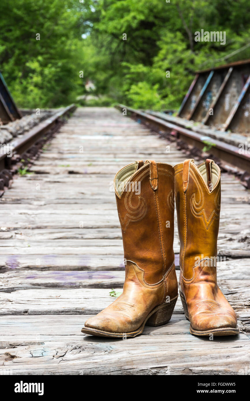 Cowboy boots on an old railroad trestle. Stock Photo