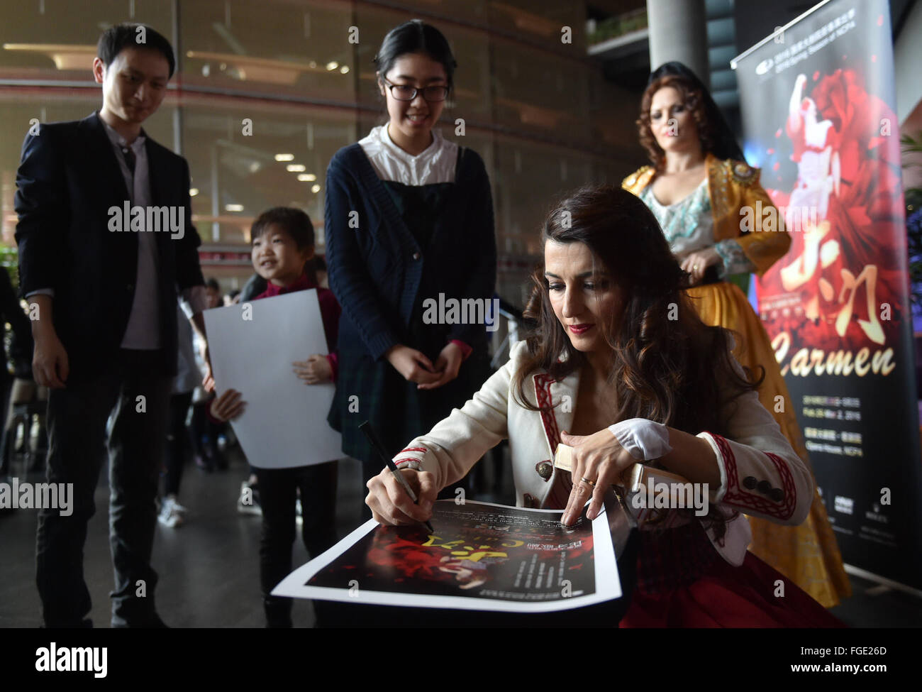 Beijing, China. 19th Feb, 2016. Actress Giuseppina Piunti autographs for her fans at a press meeting of opera Carmen in China's National Center for the Performing Arts in Beijing, capital of China, Feb. 19, 2016. The opera Carmen will meet the audience from Feb. 26 to March 2 in Beijing. © Luo Xiaoguang/Xinhua/Alamy Live News Stock Photo