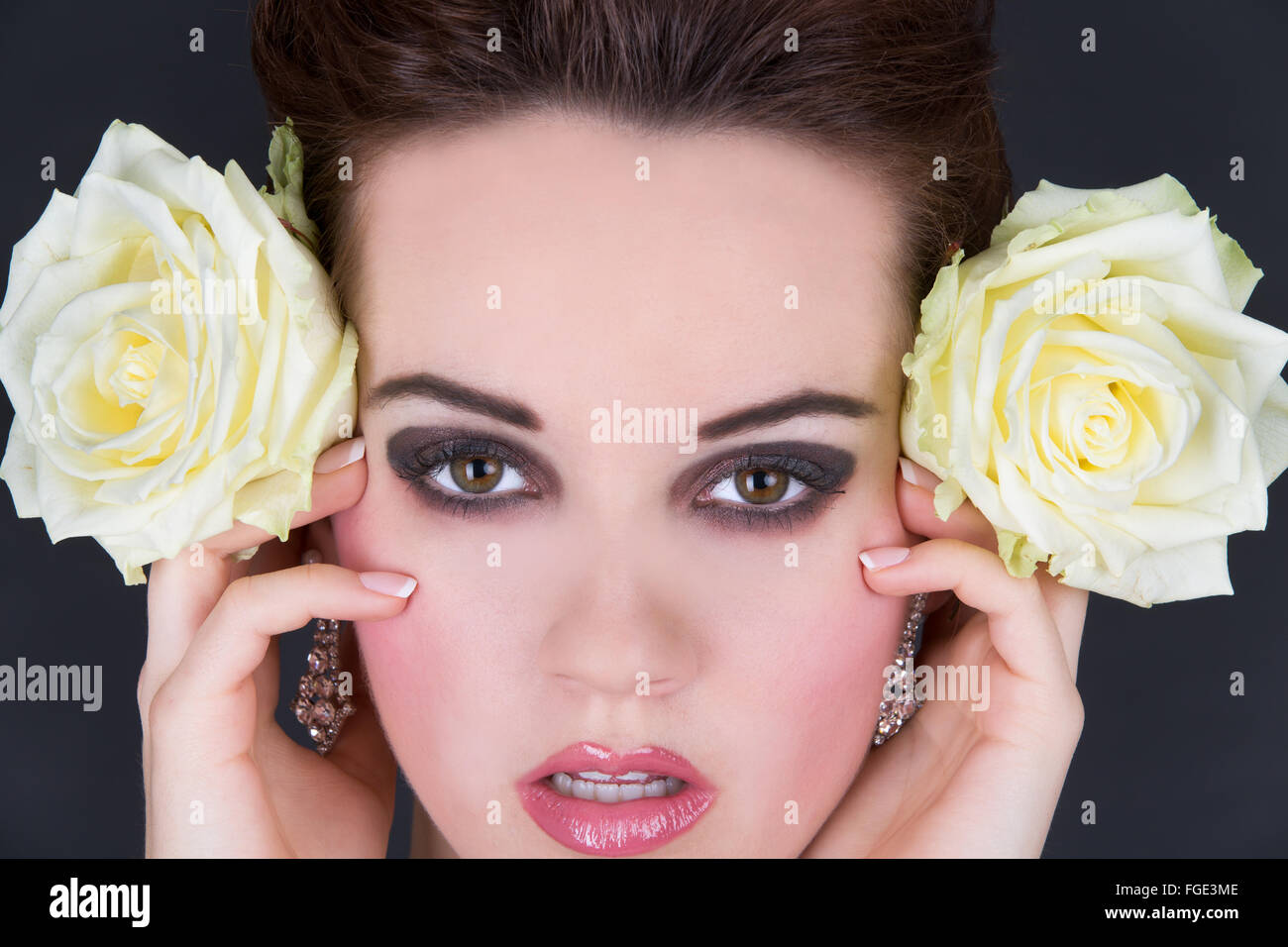 Young woman holding two yellow roses laterally nex Stock Photo