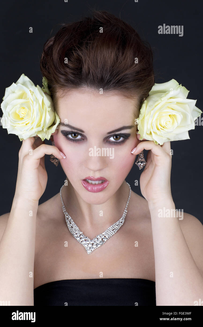 Young woman holding two yellow roses laterally nex Stock Photo