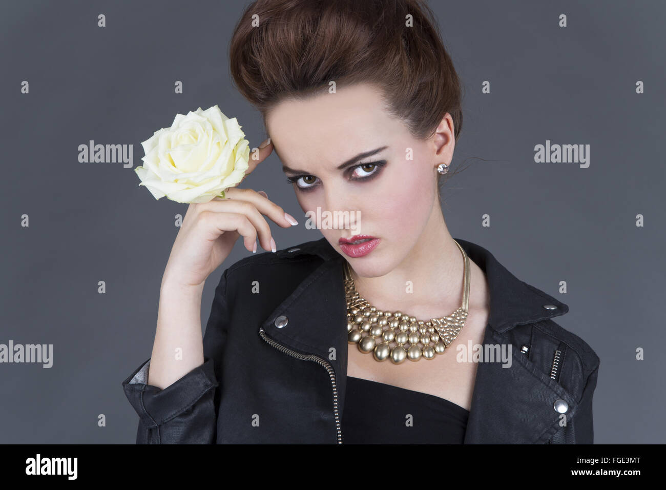 Young woman in leather outfit with white rose Stock Photo