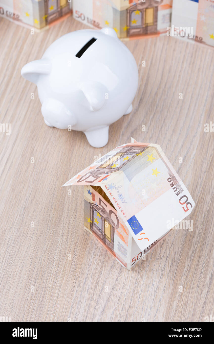 Bank note house with piggy bank Stock Photo - Alamy