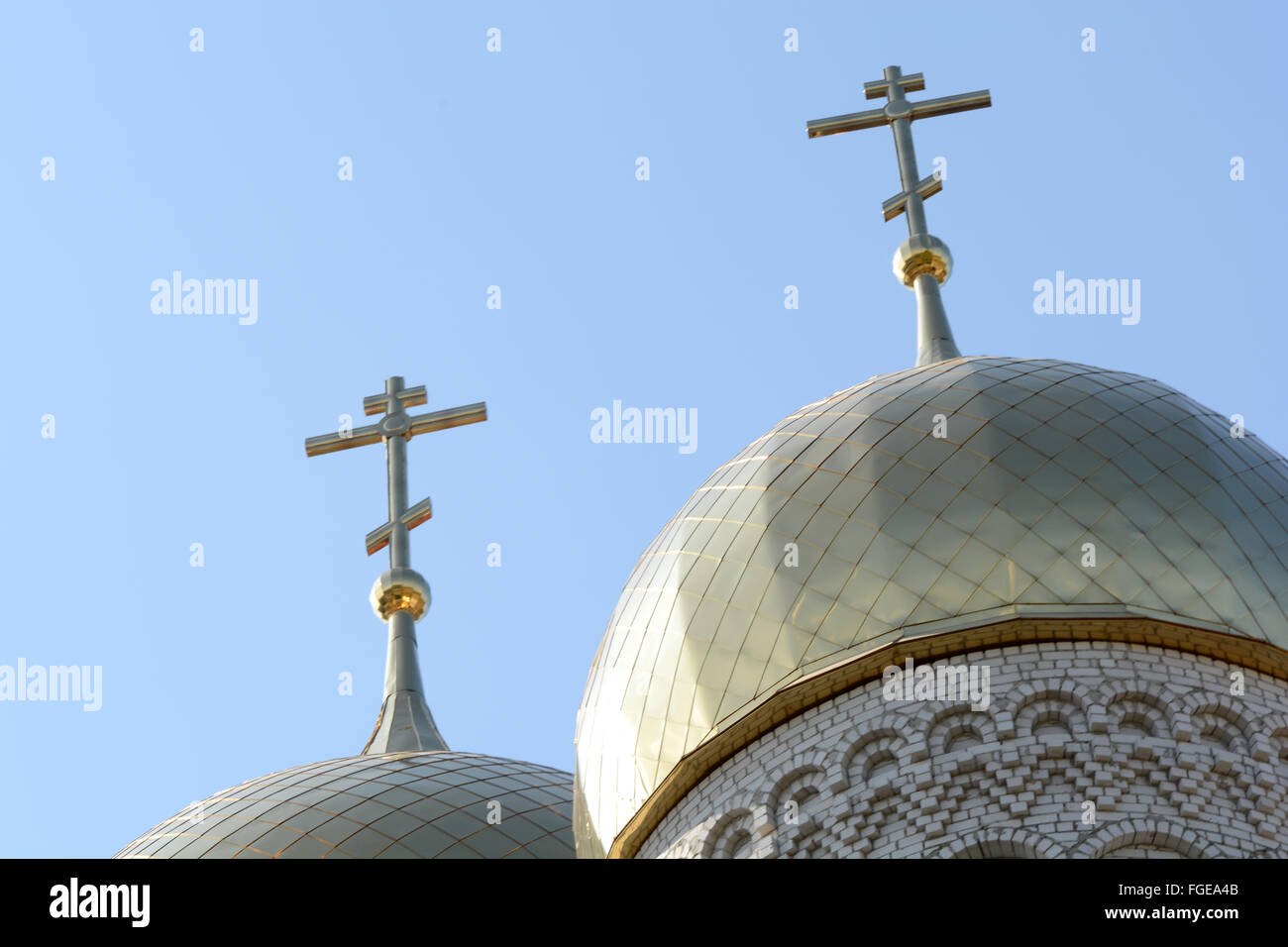 Golden cupola and christian cross on church against blue sky Stock Photo
