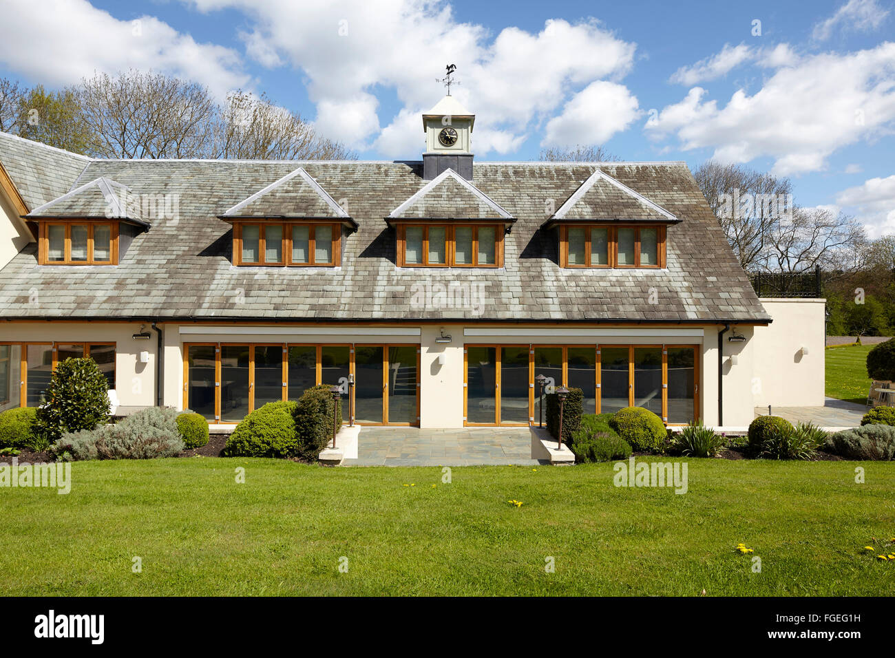 Exterior of pool room with clock tower and dormer windows. Tudor Hall