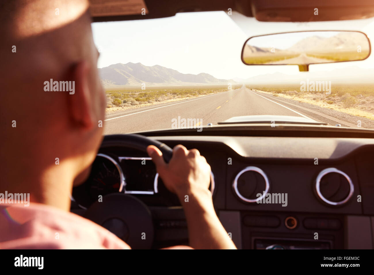 Man In Convertible Car Driving Along Open Road Stock Photo