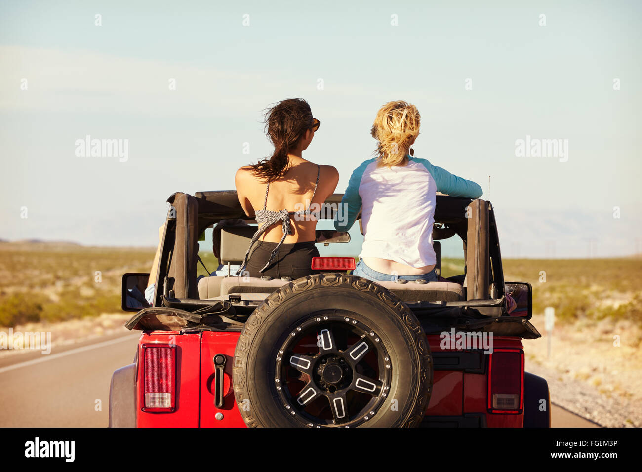 Rear View Of Friends On Road Trip Driving In Convertible Car Stock ...