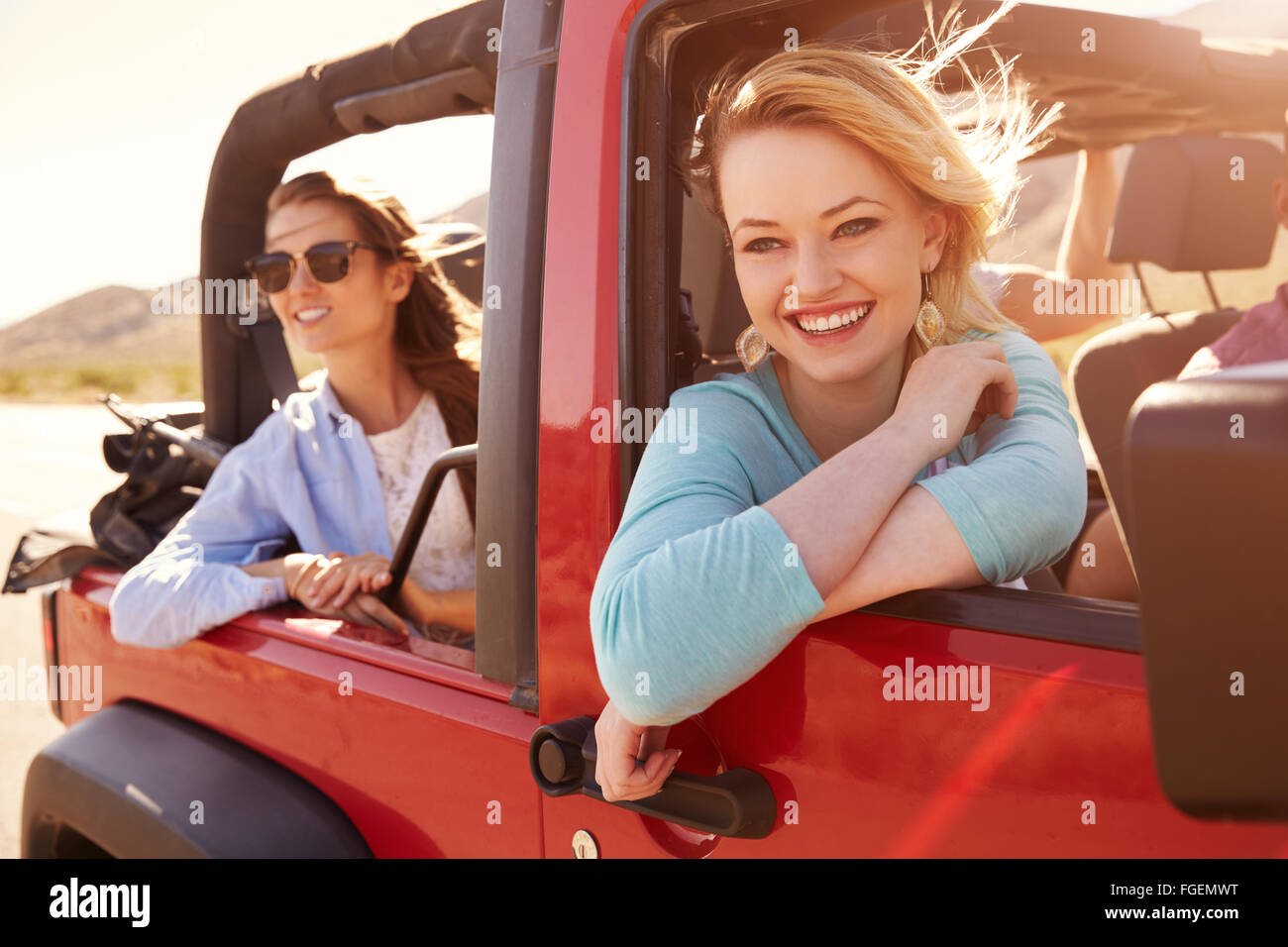 Two Female Passengers On Road Trip In Convertible Car Stock Photo
