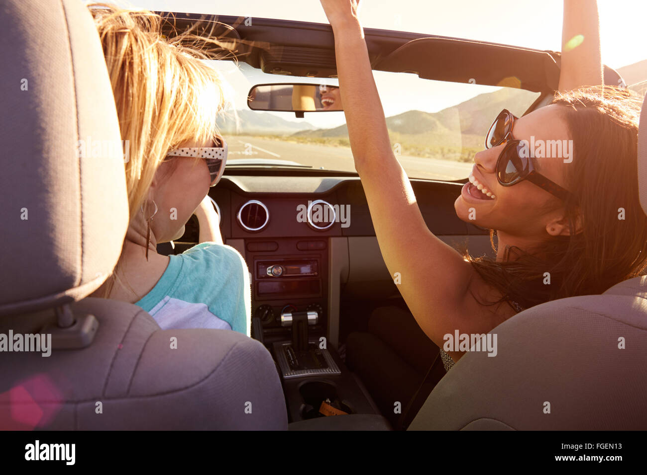 Two Female Friends On Road Trip Driving In Convertible Car Stock Photo
