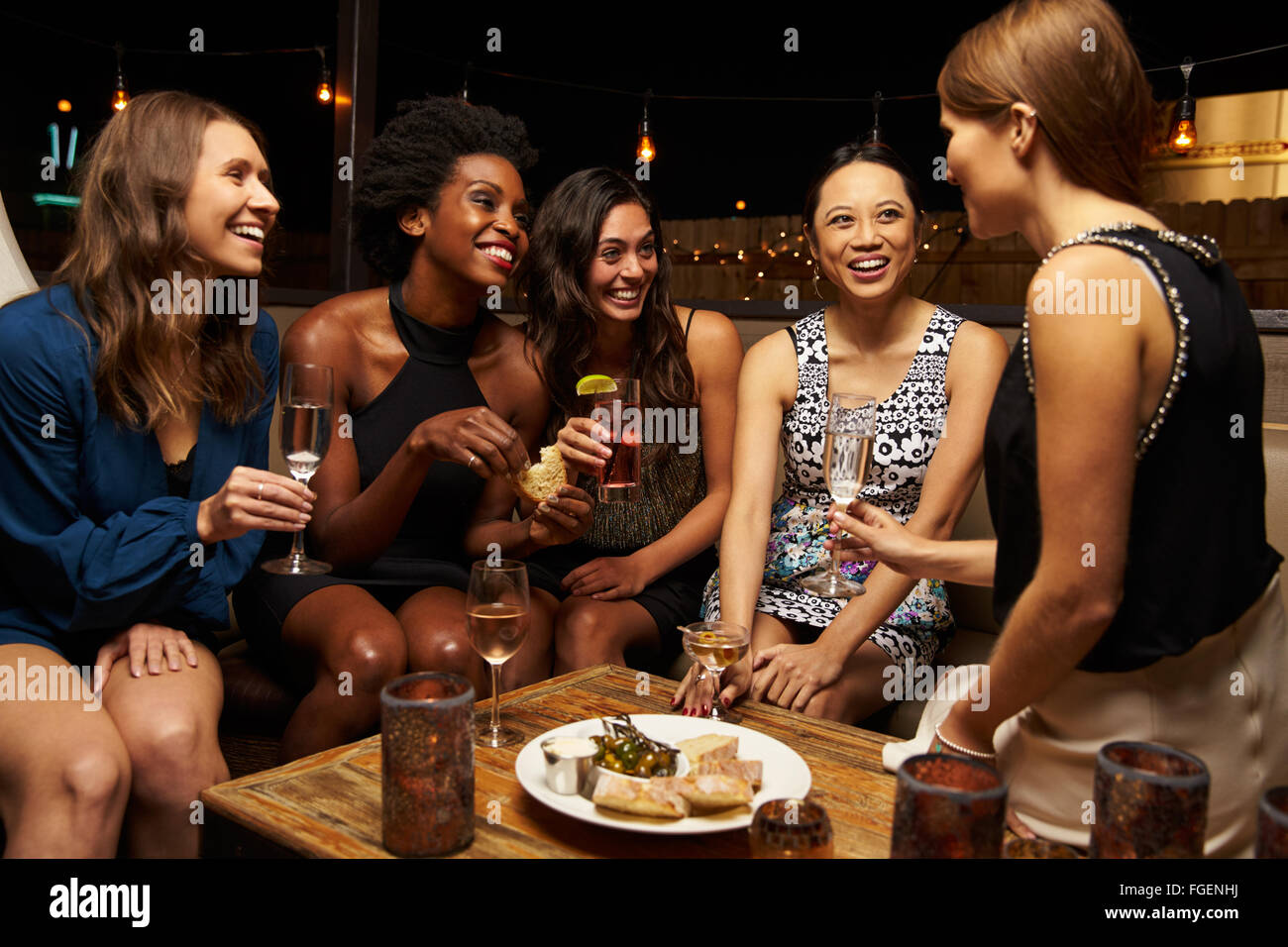 Group Of Female Friends Enjoying Night Out At Rooftop Bar Stock Photo ...