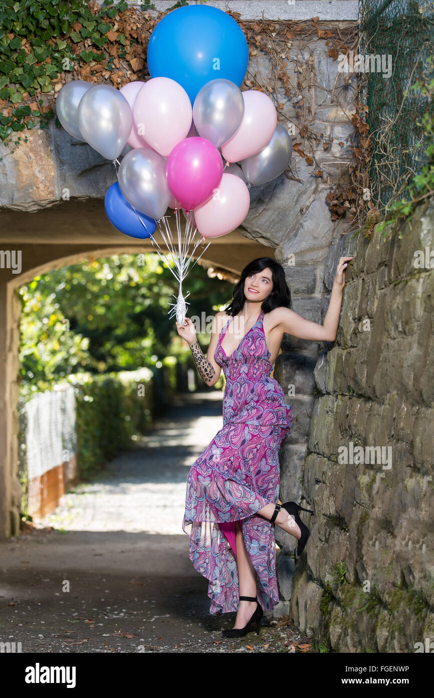 Young woman with long dress posing with colorful b Stock Photo