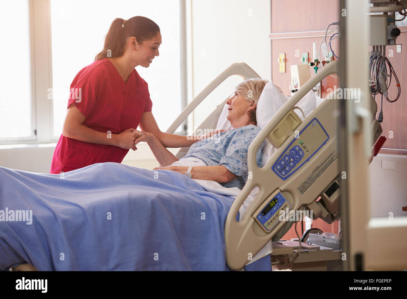 Nurse Talking To Senior Female Patient In Hospital Bed Stock Photo - Alamy